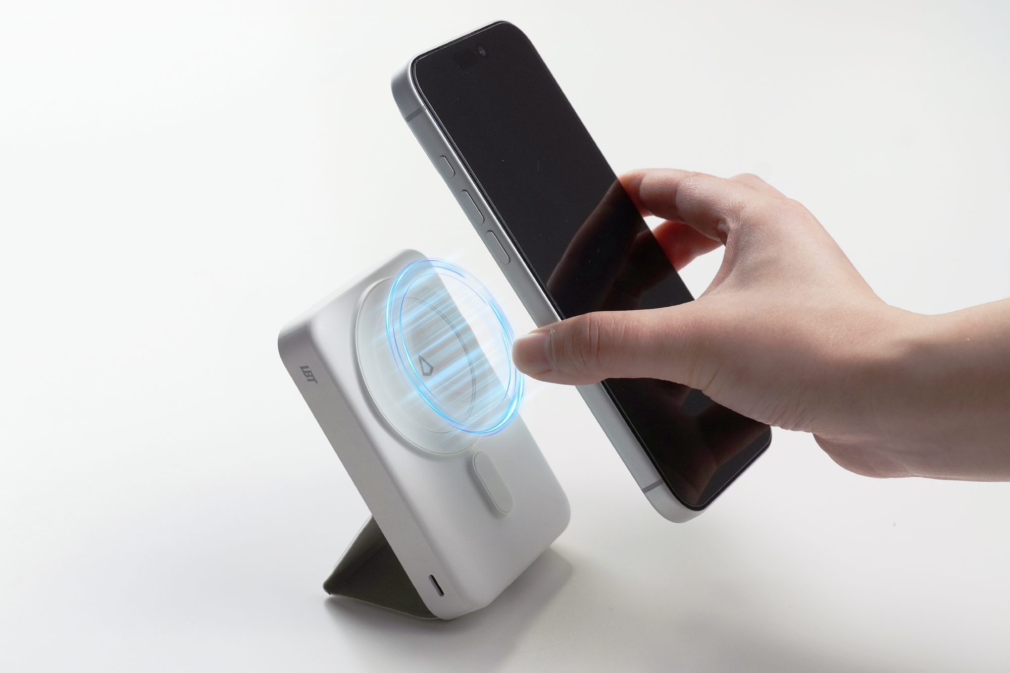 Hand using a smartphone to attach to a power bank on a white background